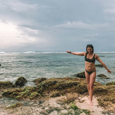 Kennedy Long retreat assistant standing on rocks in ocean